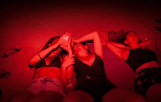 Grup de noies estirades a la platja de nit