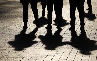 Silueta d'un grup de persones i la seva ombra projectada al carrer