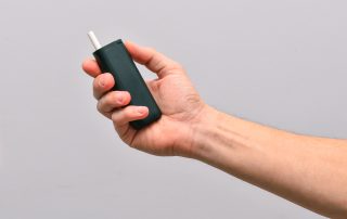 Mano sujetando dispositivo de tabaco calentado